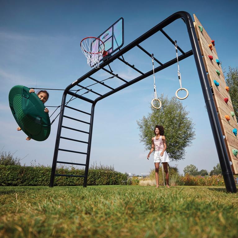 BERG PlayBase climbing frame installed in a garden with nest swing, gym rings and climbing wall